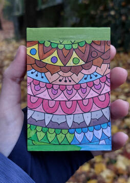 This is a photo of me holding up the lil sketchbook